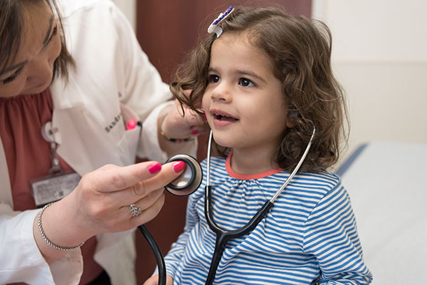 Doctor showing child patient a stethoscope
