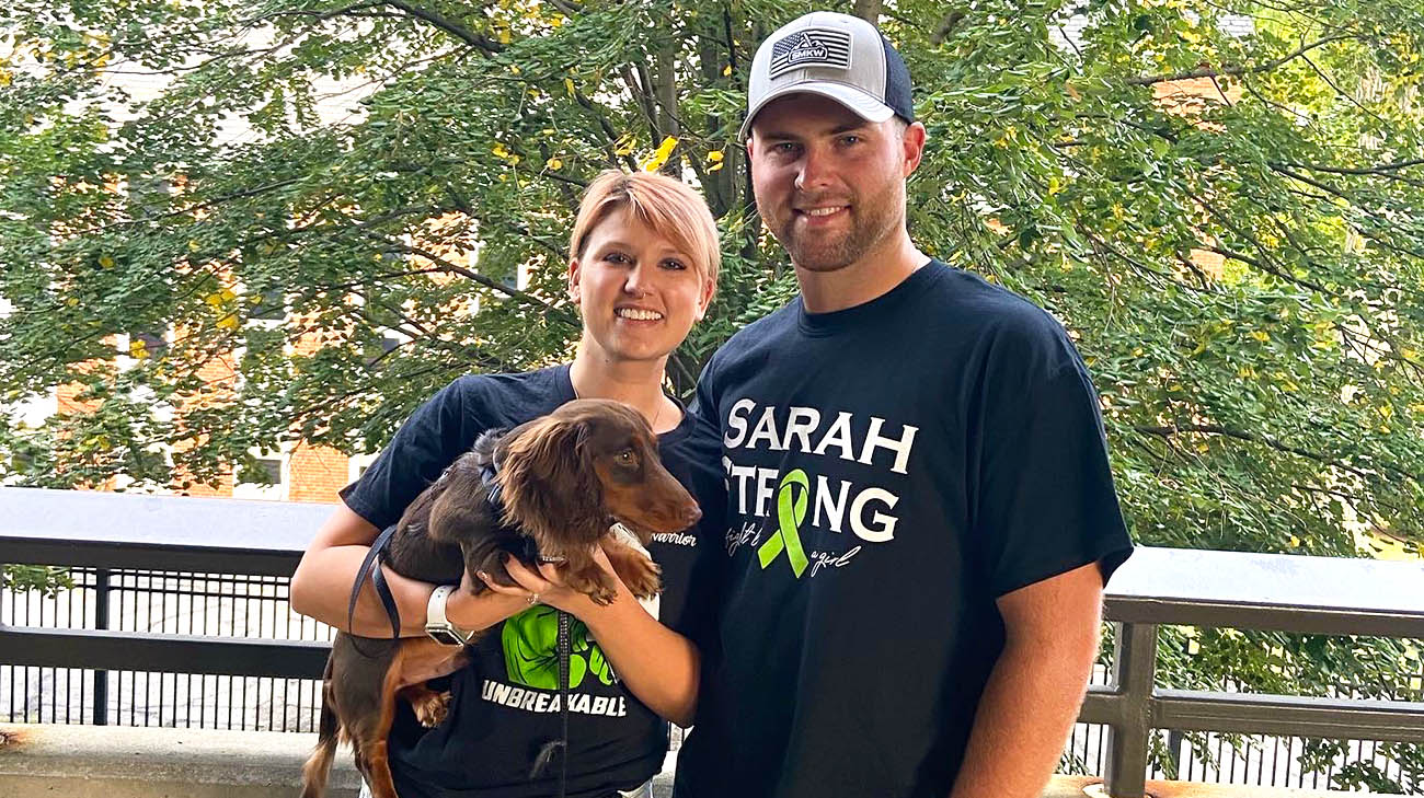 Sarah, her husband, Mackenzie, and their dog, Cooper, during Light The Night walk for the Leukemia & Lymphoma Society. 