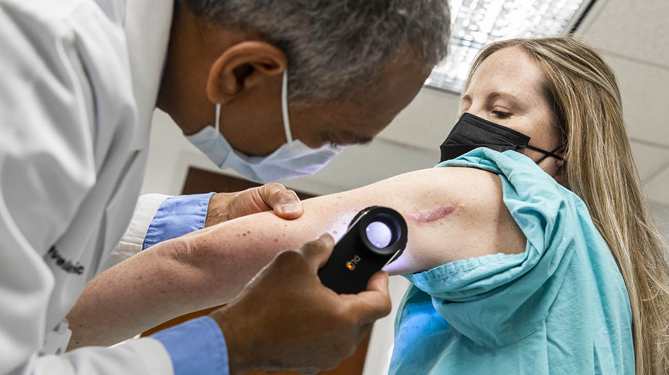 Dr. Philip Bernard checking for moles during Melissa's full-body skin exam at Cleveland Clinic. 