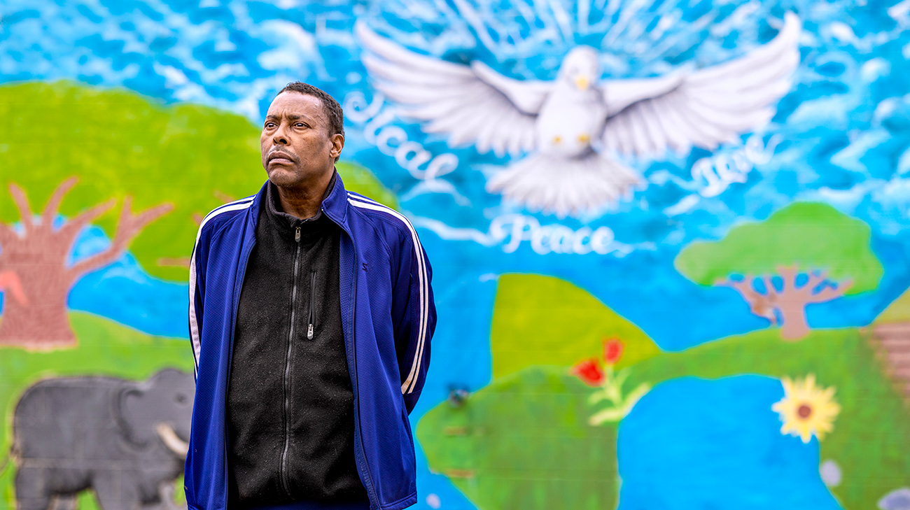 Roy in front of a mural he helped paint his community, in Akron, Ohio. 