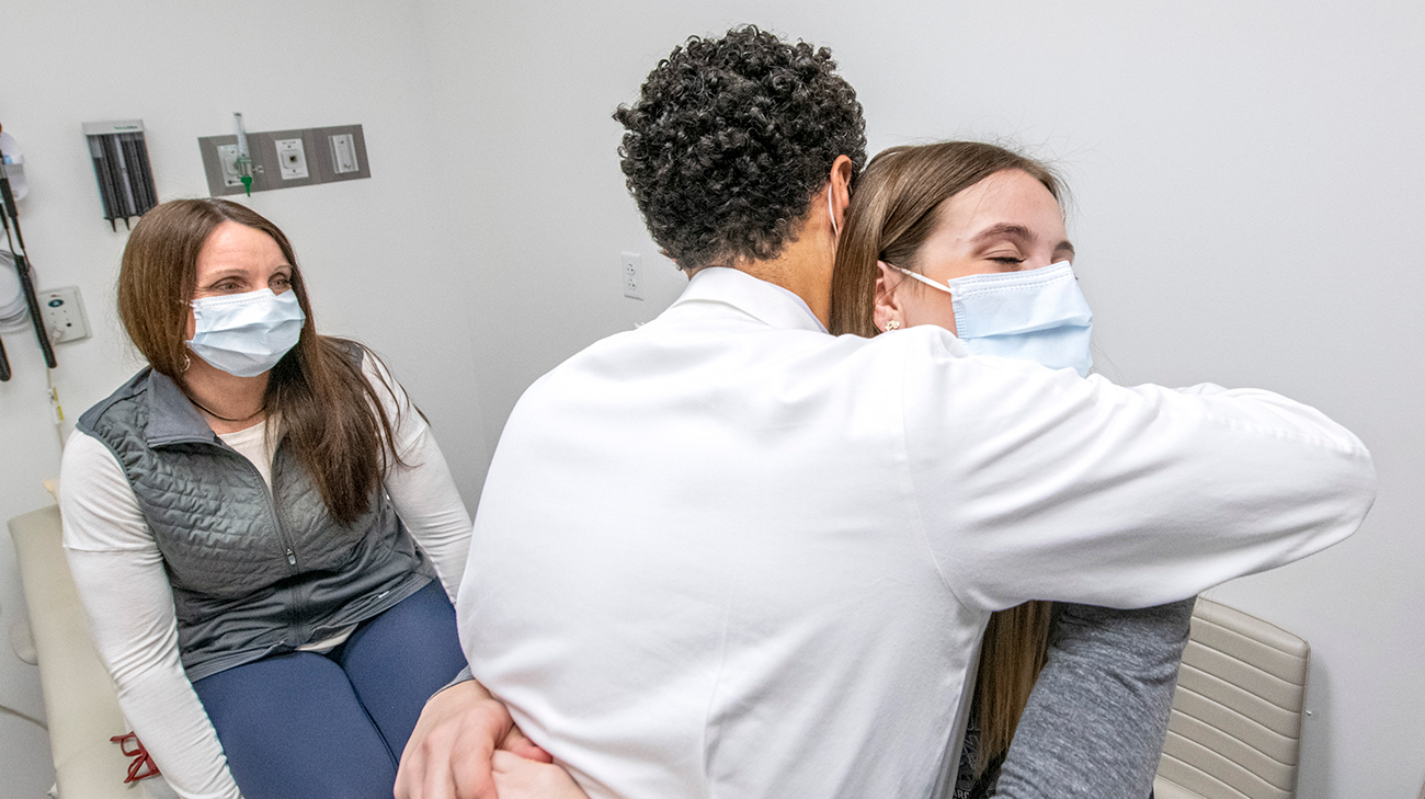 Dr. Aziz and Abby hug at a follow-up appointment.