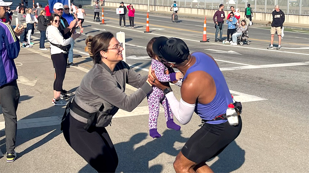 John stops to give his daughter a kiss while running a marathon.