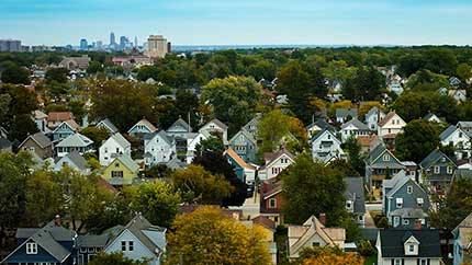 Suburban houses with city skyline in the background.