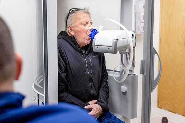 A man blowing into a medical device.