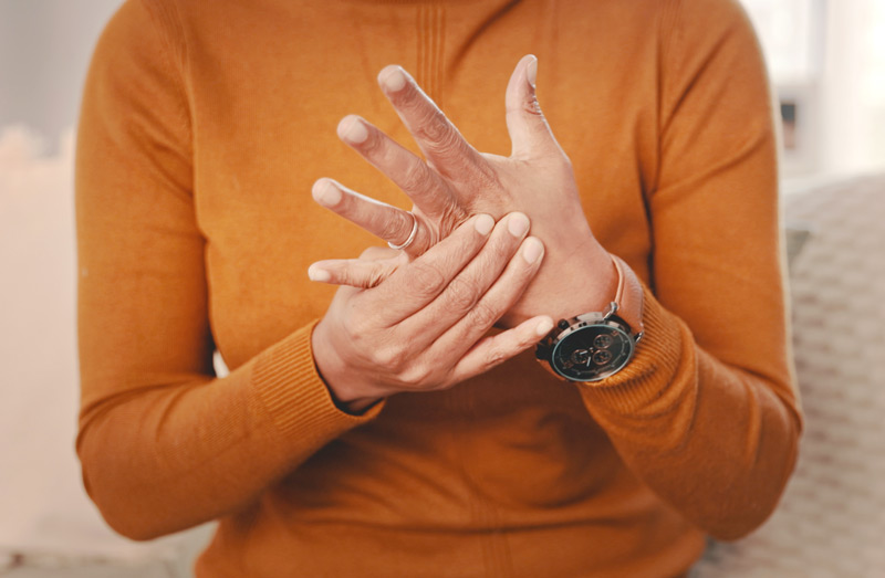 Woman holding her hand near the left ring finger, in pain from ring avulsion.