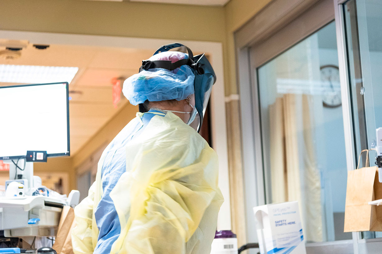 A person in personal protective gear ready to help a patient.