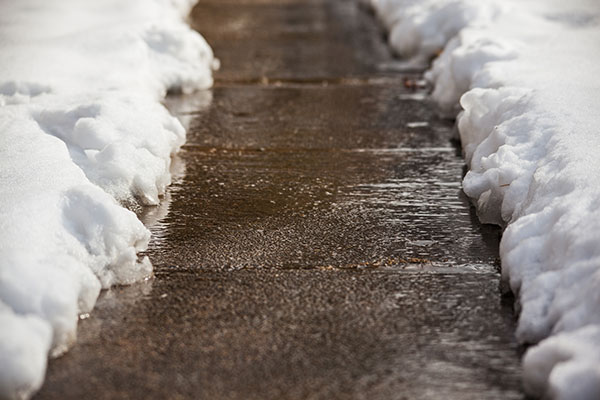 A sidewalk with snow.