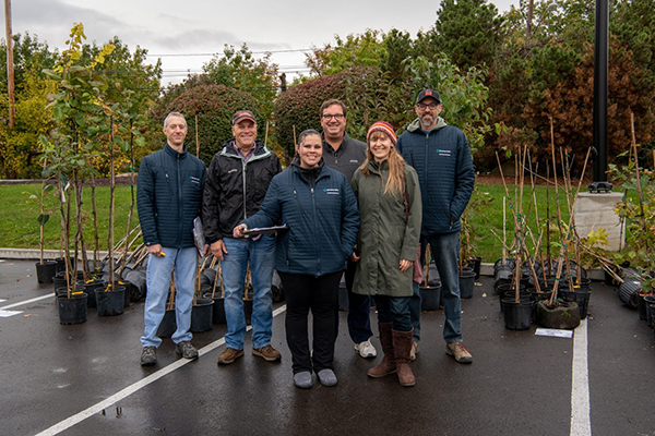 Group of Cleveland Clinic employees standing in front of potted trees.