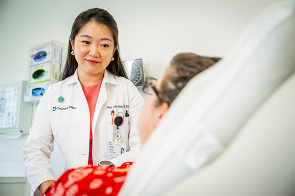 A Cleveland Clinic doctor talking to a patient lying in bed.