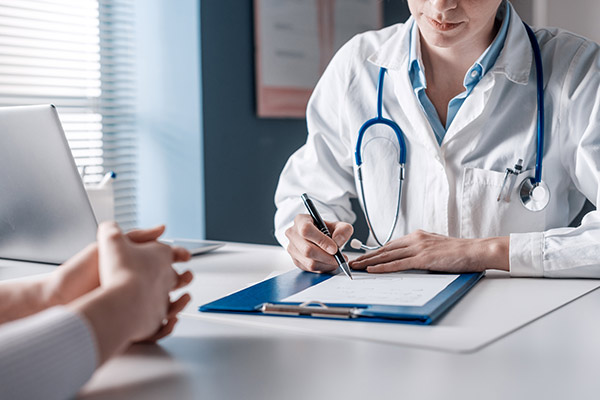 A doctor review information on a clipboard.