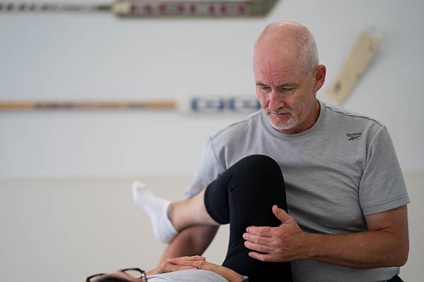 Caregiver stretching a patient's leg.