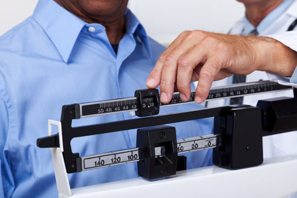 Weight & Lifestyle Management - Man on scale | Cleveland Clinic Canada