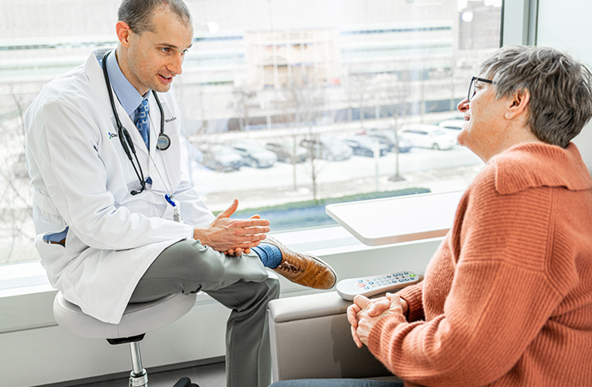 Male doctor speaking with female patient.