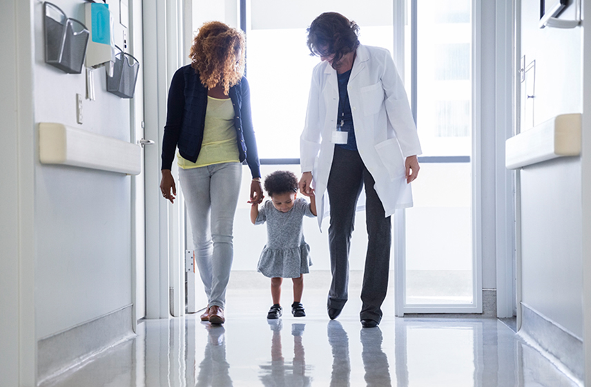 Doctor and mother walking with a child