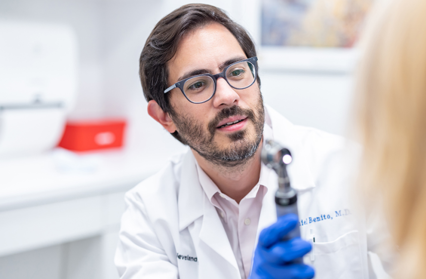 Cleveland Clinic doctor holding and Otoscope.