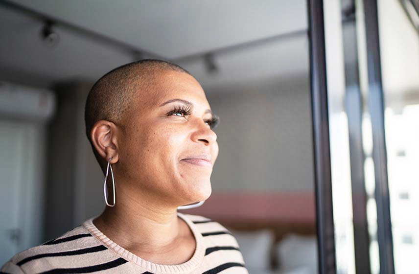 Woman with a shaved head due to chemotherapy treatment is hopeful following remission.
