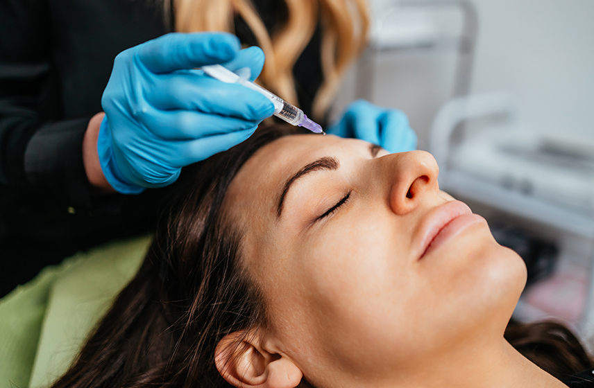 A person receiving injectables in their forehead. 