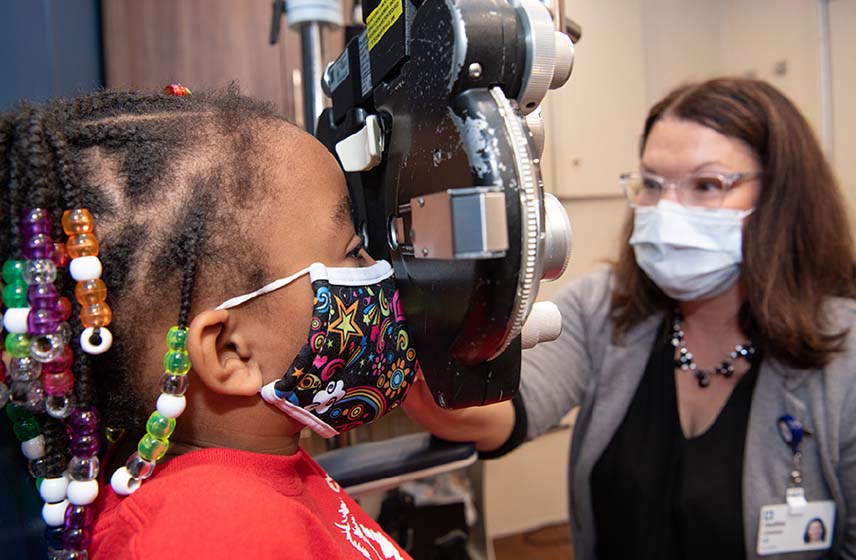 Cleveland Clinic pediatric ophthalmologist performing an eye exam on a child.