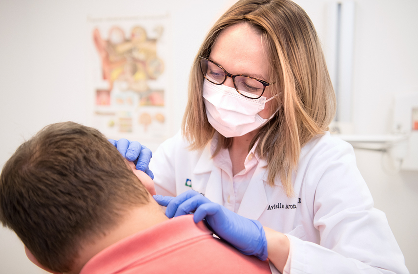 Cleveland Clinic doctor looking into a patients ear.