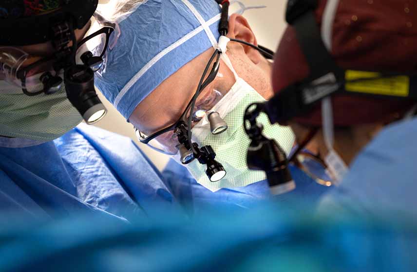 Cleveland Clinic surgical team performing facial trauma reconstruction surgery on a patient in the operating room.