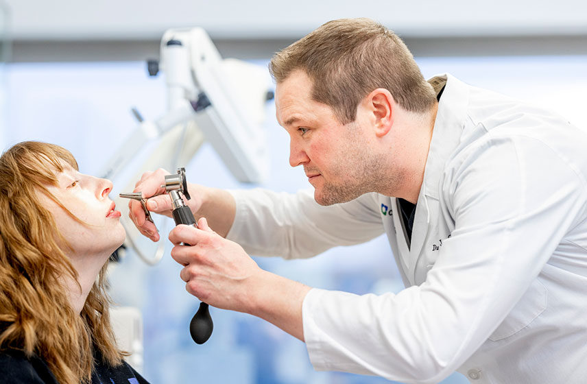 Cleveland Clinic doctor placing a device up a patient's nose.