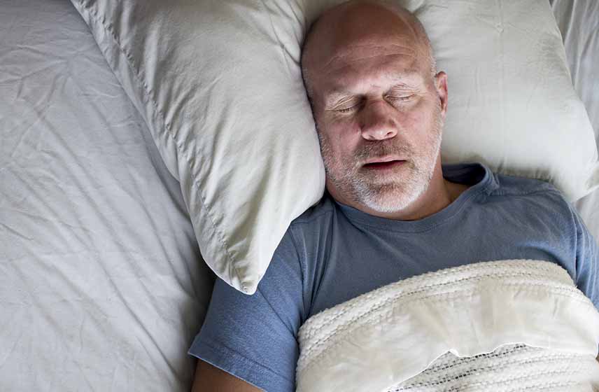 Man lying in bed snoring.