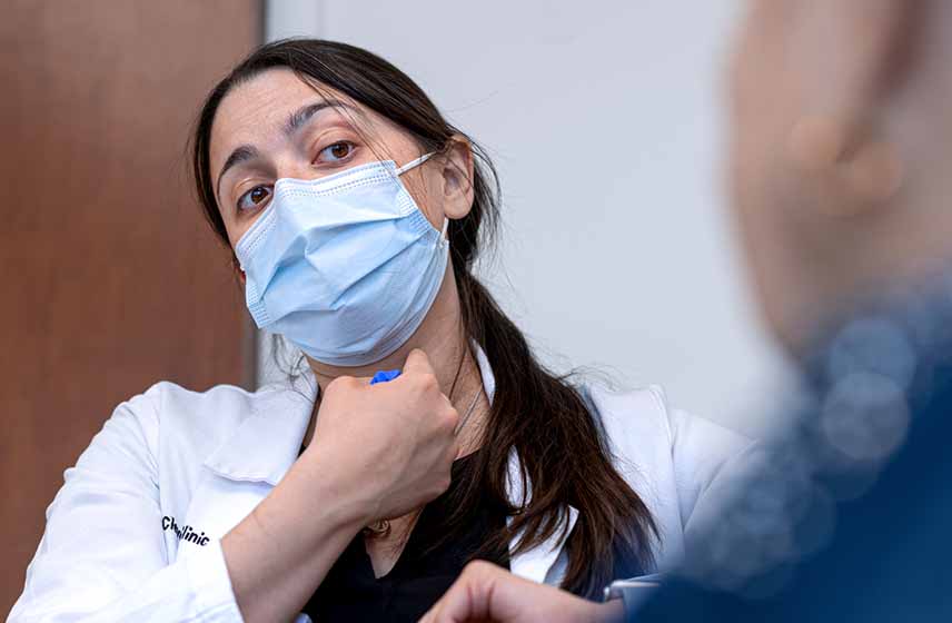 Cleveland Clinic doctor pointing at a location on her neck as an example for her patient.