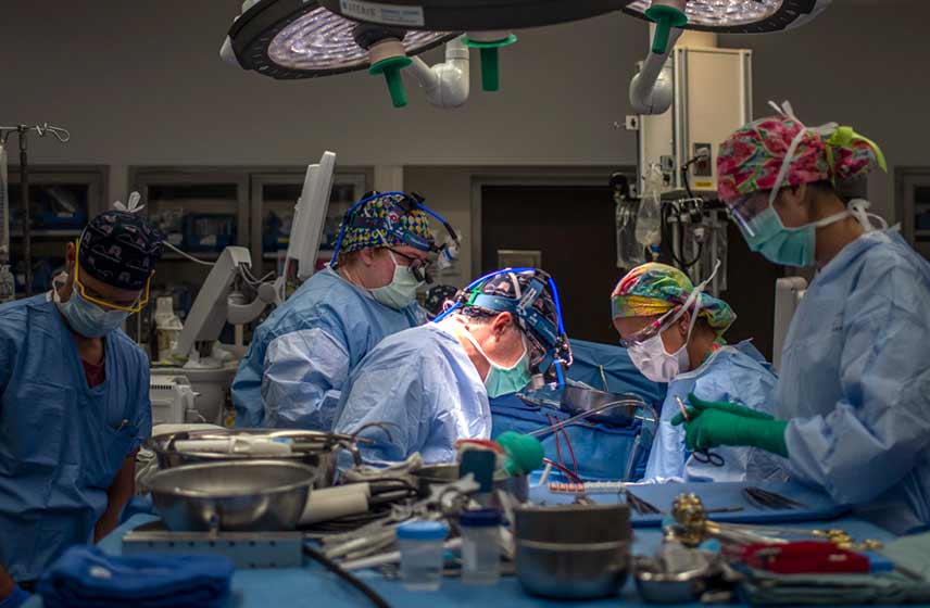 Surgeons in an operating room performing heart surgery.