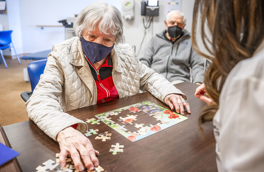 A woman with Alzheimer's doing a puzzle.