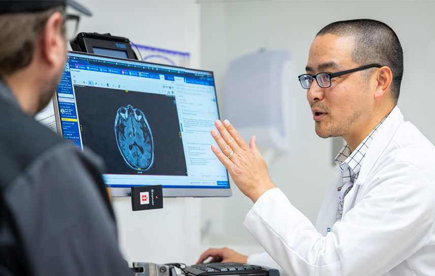 A caregiver and patient looking at a cranial scan.