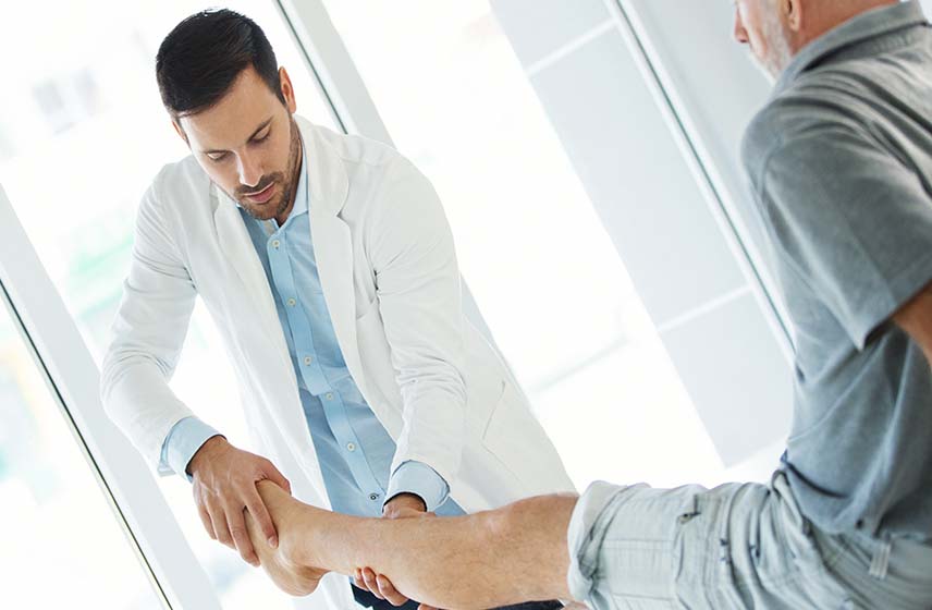 A caregiver examining ankle pain on a patient.