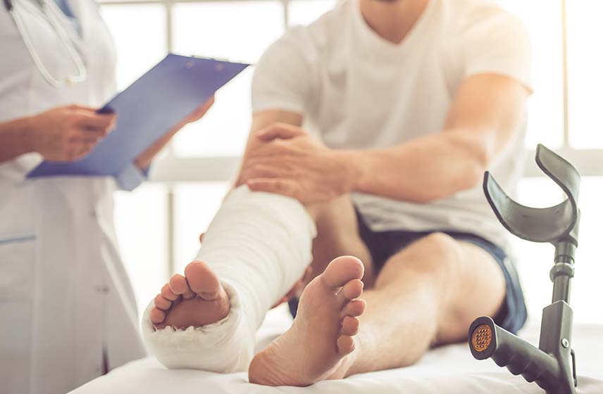 Patient with a cast on right leg in exam room with provider