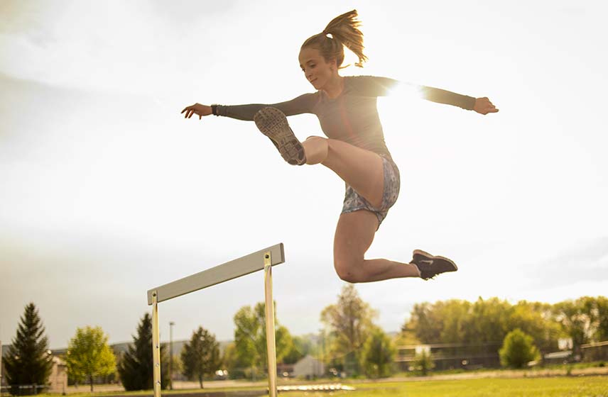 Photo of runner jumping over hurdles