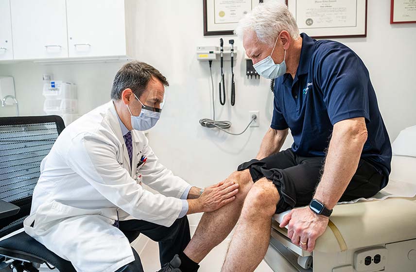 Doctor examining patient with knee pain