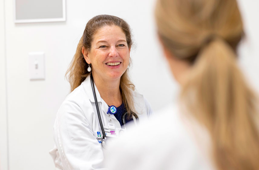 Doctor talking with patient in a medical office setting.