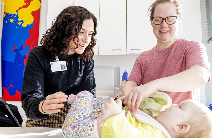 Cleveland clinic caregiver working with a pediatric patient and their mom.