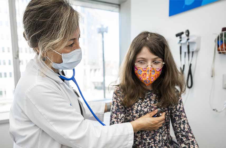 Cleveland Clinic Children's doctor examining child's breath sounds with a stethoscope.