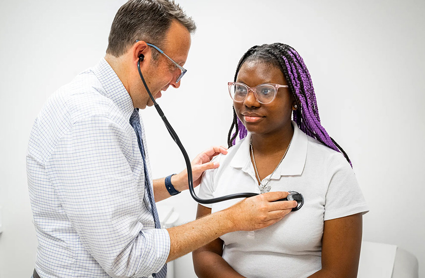 Caregiver examining patient with stethoscope