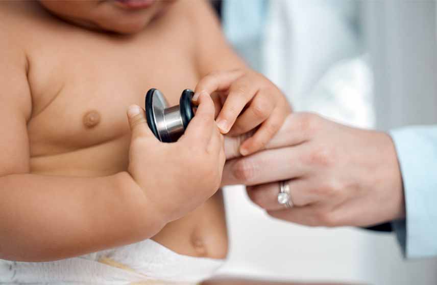 Doctor examining baby's heart sounds using a stethoscope.