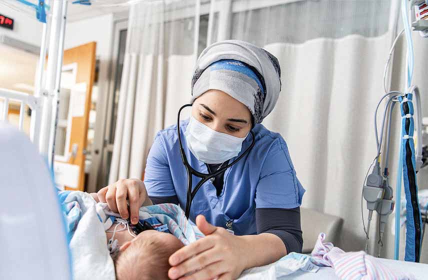 Cleveland Clinic Children's nurse checking breath sounds of a newborn baby.