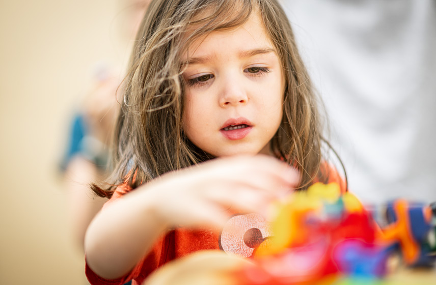 Young girl playing with learning blocks and toys.