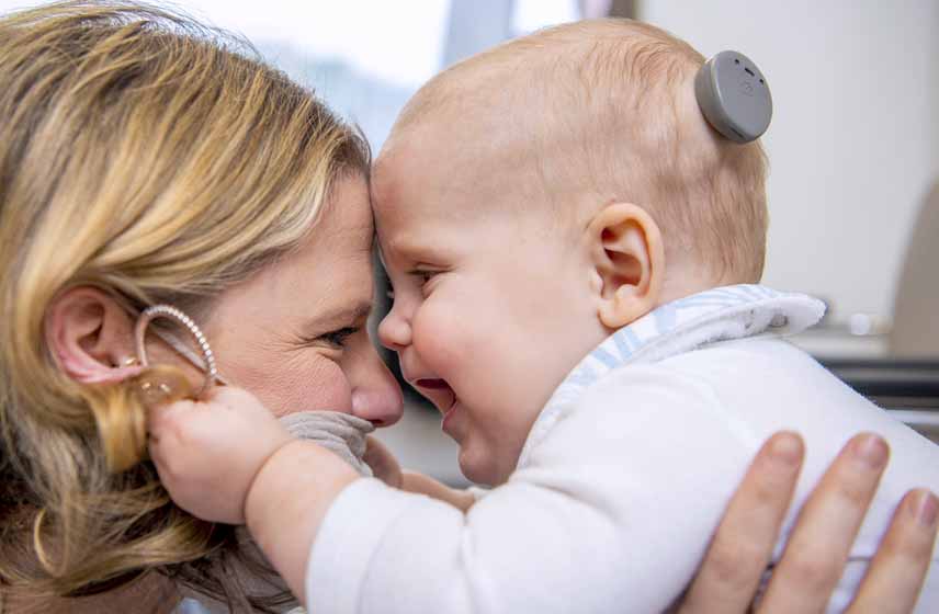 Mother embracing her child who has received a cochlear implant.