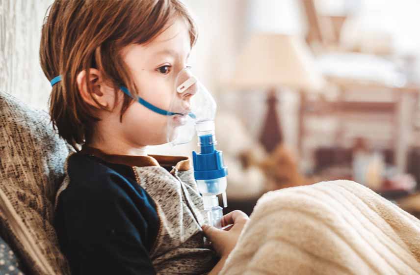 Child wearing mask covering his mouth and nose for breathing treatment.