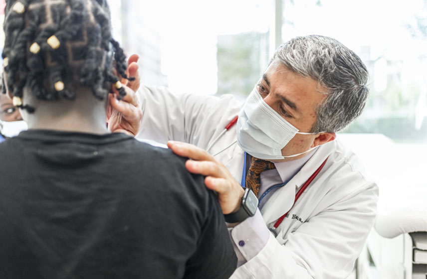 Cleveland Clinic Pediatrician checking a patient's thyroid gland