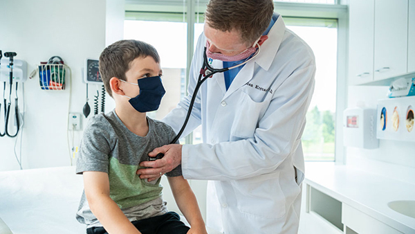 Pediatrician listening to heart beat of child