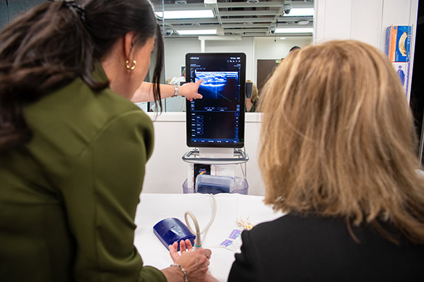 Two people looking at an ultrasound image on a screen.