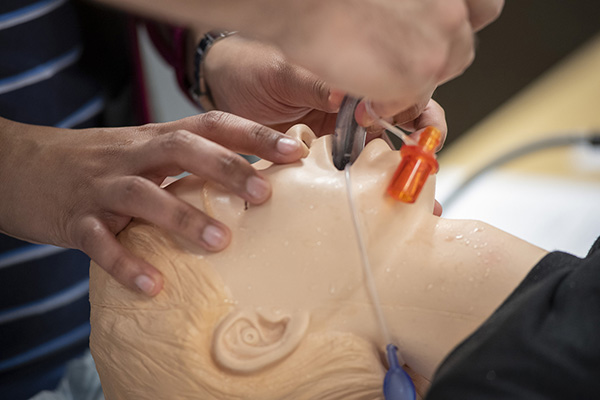 students training with a medical mannequin