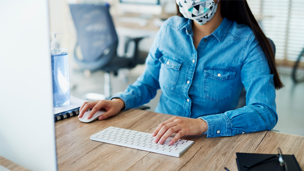 Woman in mask standing in empty office