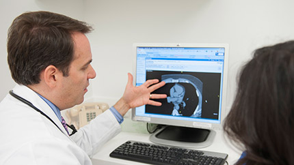 Executive Health physician showing scan to patient