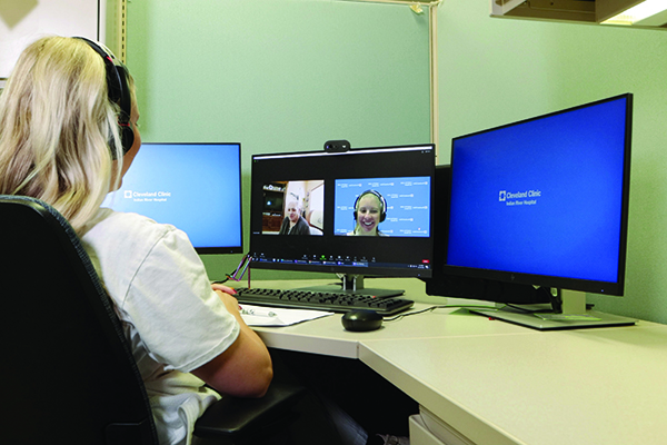 Caregiver and patient having a video visit for hospital care at home.